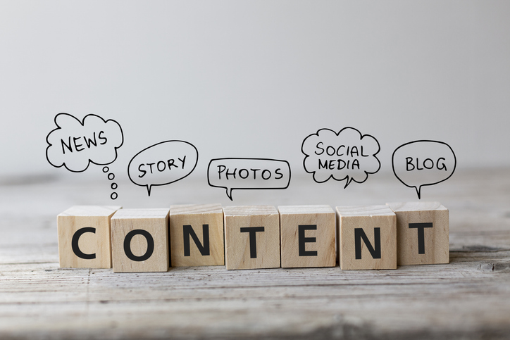 Wooden cubes arranged to spell “CONTENT” surrounded by small speech bubble icons, symbolizing messaging, communication, and digital marketing strategy.