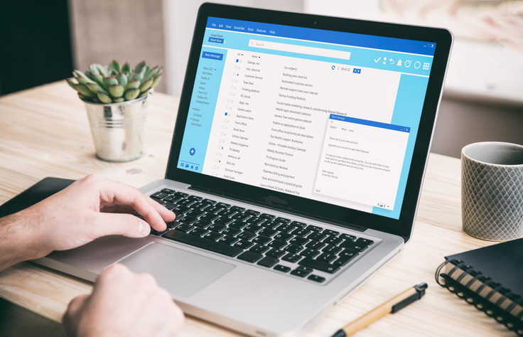 Computer user managing an email marketing campaign, reviewing email message communication, and organizing a client mailing list on a laptop screen with an inbox interface and a contact database visible.