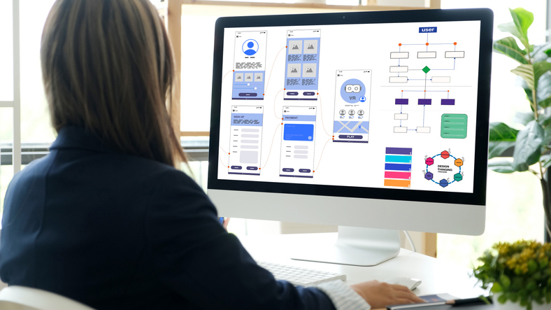 Website designer working on creative planning and wireframe layouts for website development, organizing template frameworks and interface design to optimize user experience and site functionality.